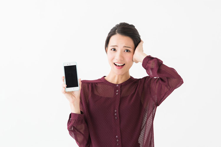 iPhoneを手に困っている女性
