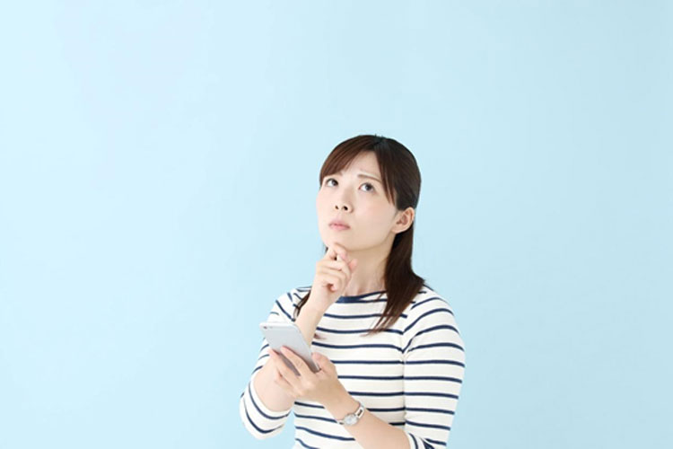 iPhoneを手に困っている女性