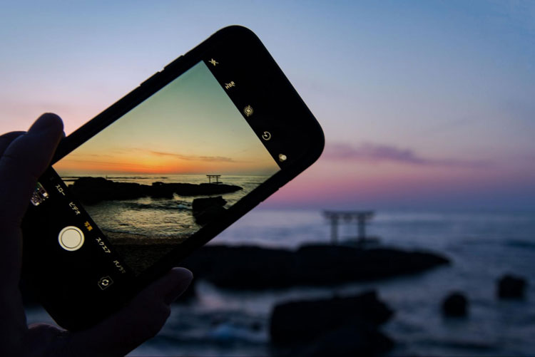 iPhoneで海辺の写真を撮影する様子